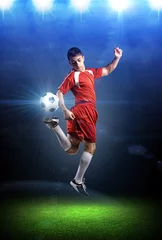 Fototapeten The football player in action in the stadium. © efks