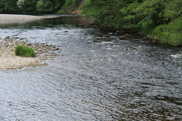 A Shallow River Flowing Past a Rocky Island.