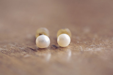 Fashionable earrings on wooden background