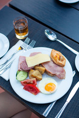 Plate of Breakfast with fried eggs, ham and vegetables