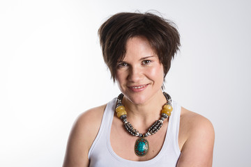 gl&uuml;ckliche junge Frau mit braunen Haaren und Kette