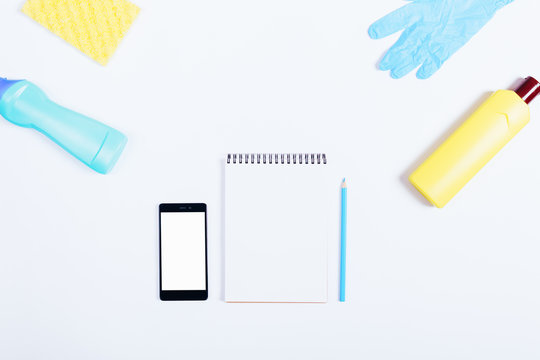 Mobile phone, notebook, pencil, yellow and blue bottle of deterg