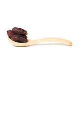 A dried dates in a wooden spoon isolated over white background