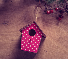 red birdhouse hang on pine with antique rustic wood background.