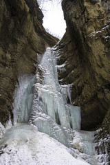 Fototapeta na wymiar замерзший водопад между горными скалами, зимний пейзаж