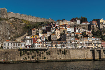 Fototapeta na wymiar A steep bank of the river Douro on which houses are built next to the medieval city wall