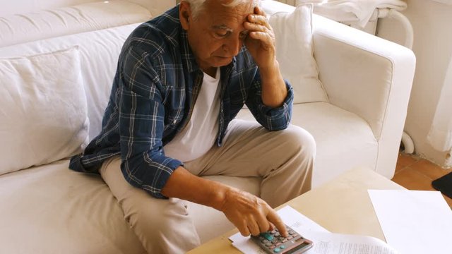 Tensed senior man checking the bills at home 4k