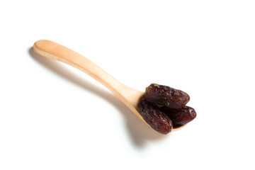 A dates in a wooden spoon isolated over white background