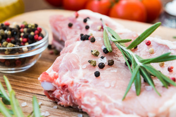 Raw meat on bone with rosemary, thyme, pepper and garlic