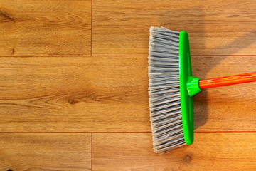 cleaning wooden floor with broom