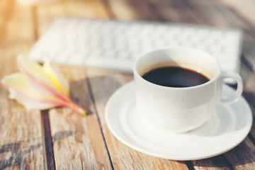 coffee cup and keyboard on wooden table