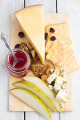cheese, pear, crackers, jam top view on a white background