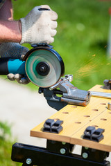 Metal worker cutting metal with angle or disc grinder outdoor