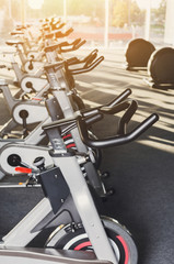 Modern gym interior with equipment, fitness exercise bikes handlebars