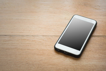 smart phone with blank screen on wood background.