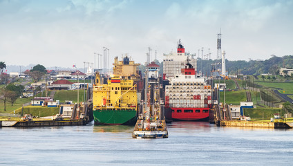 panama canal,  a cargo ship entering the miraflores locks in the