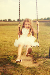 Cute Girl Swinging In Park