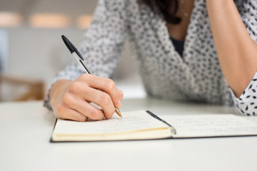 Woman writing on organizer