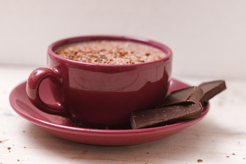 Milk chocolate in a cup on a saucer against a background of a sc