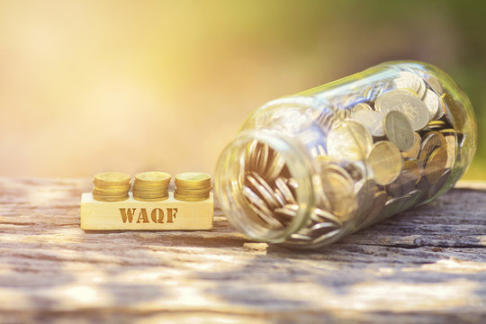 WAQF WORD Golden coin stacked with wooden bar on shallow DOF