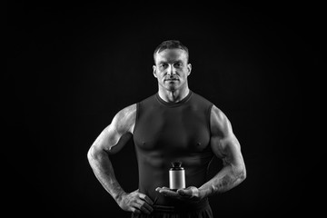 Obraz na płótnie Canvas handsome sexy athlete man with muscular body holds steroid jar