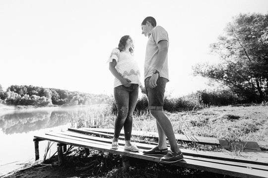 Black and white photo of lovely expecting couple standing by the