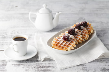 Brussels waffles with blackberries on white plate