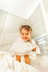 Portrait of cute kid boy having fun in his bedroom