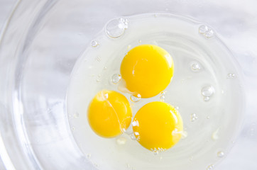 Beautiful picture of eggs in a white bowl with beaters near yolk
