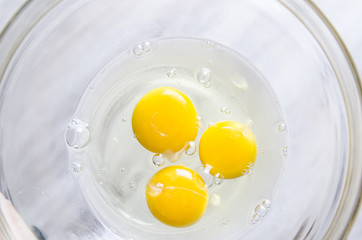 Beautiful picture of eggs in a white bowl with beaters near yolk
