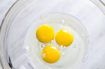 Beautiful picture of eggs in a white bowl with beaters near yolk