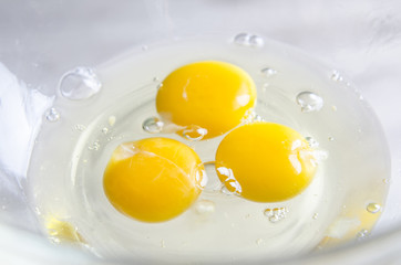 Beautiful picture of eggs in a white bowl with beaters near yolk
