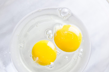Beautiful picture of eggs in a white bowl with beaters near yolk