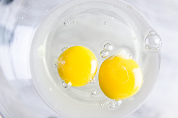 Beautiful picture of eggs in a white bowl with beaters near yolk
