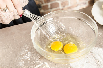 Beautiful picture of eggs in a white bowl with beaters near yolk