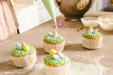 Beautiful cute Easter cupcakes with Easter decorations isolated on wood background while cooking by chef