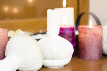Fototapeta na wymiar Traditional Medicine of Thailand, Herbal Ball for massage and spa cream decorated with lighting candles
