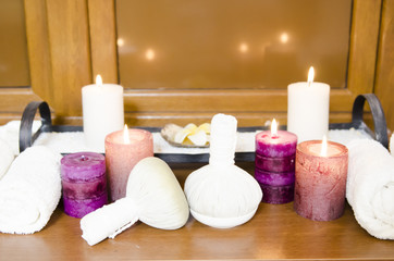 Fototapeta na wymiar Traditional Medicine of Thailand, Herbal Ball for massage and spa cream decorated with lighting candles