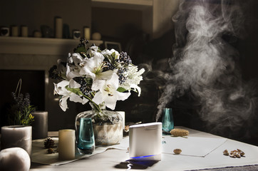 humidifier on the table near to bouquet of flowers, in home interior - obrazy, fototapety, plakaty