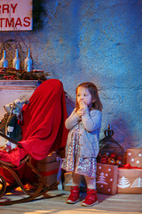 Little girl and rocking chair near fireplace