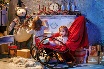 Little girl and rocking chair near fireplace