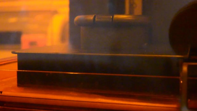 Stereolithography DPL 3d printer create detail and liquid drips, platform slowly move with liquid close-up. Progressive modern additive technology 3D printing, create scaled model by UV polymerization