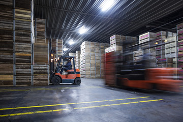Worker on forklift in factory warehouse