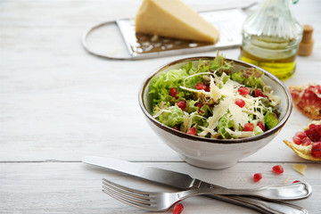 Salad lettuce with parmesan cheese and pomegranate seeds 
