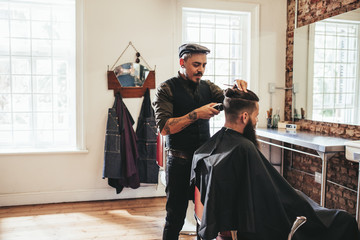 Male barber giving client haircut © Jacob Lund
