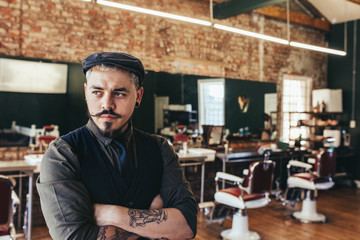 Stylish hairdresser standing at his shop