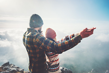 Naklejka premium Couple Man and Woman holding hands raised on mountain summit Love and Travel happy emotions feelings Lifestyle concept. Young family traveling active adventure vacations