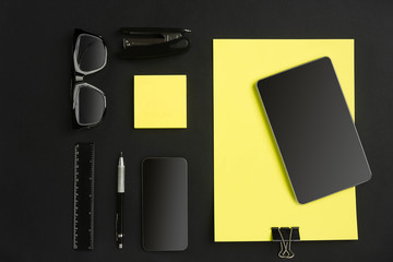 Top view of office supplies on blackboard background with copy space.