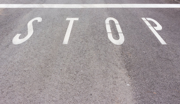 Wei&szlig;es Stopzeichen auf grauer Asphaltstrasse