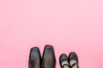 Top view daddy boots with daughter girl child on pink background